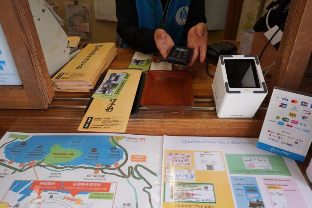 Ticket counter at Hakone Checkpoint where visitors receive a traditional paper pass after purchasing admission.