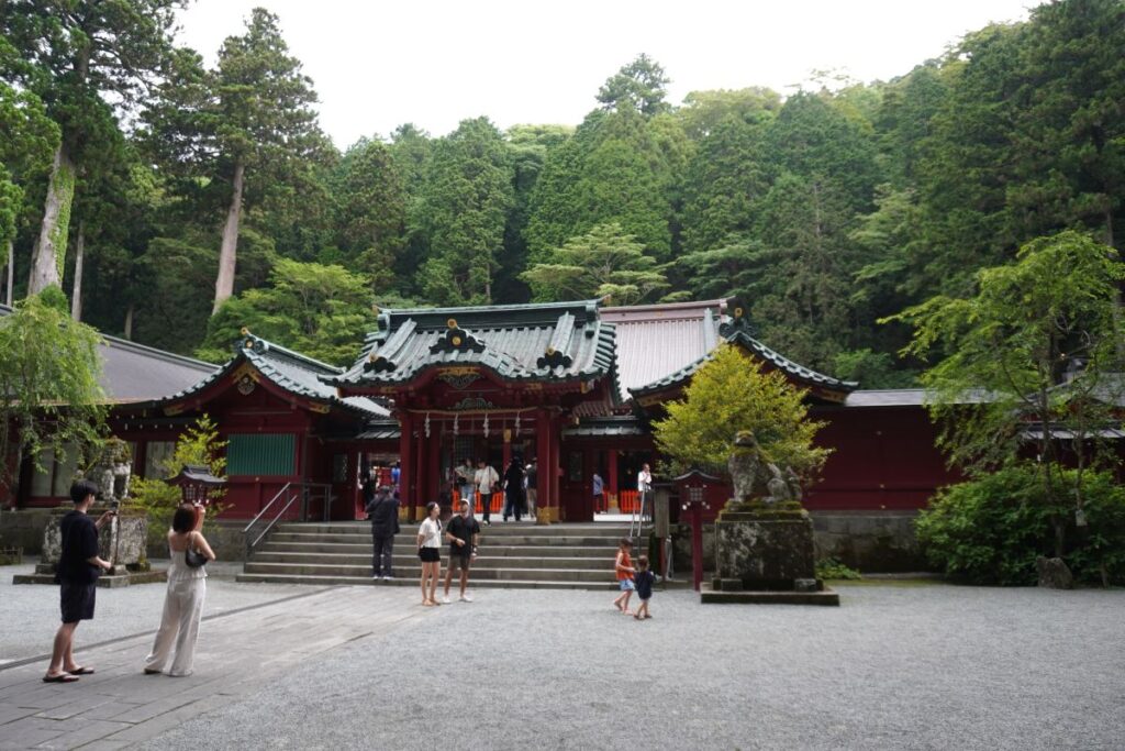 Main shrine building of Hakone Shrine surrounded by lush forest