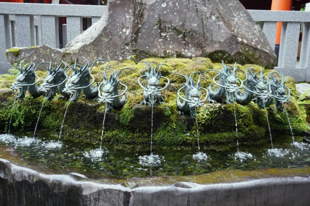 Spring water flowing from the nine dragon heads at Kuzuryu Shrine