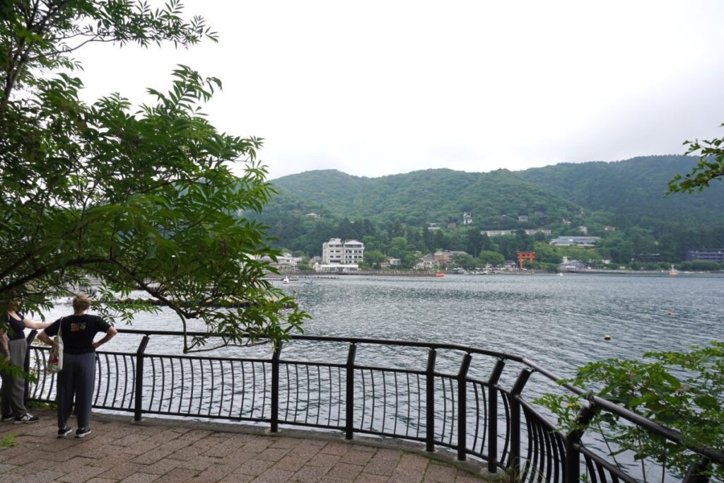 View of Lake Ashi and the distant torii gate from the lakeside promenade