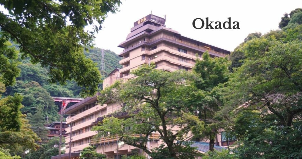 Hotel Okada in Hakone-Yumoto surrounded by lush green mountains and trees.