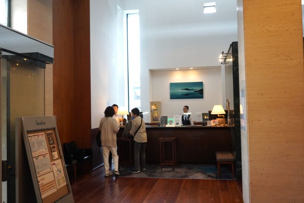 Reception area at Hakone Hotel with guests checking in at the front desk.